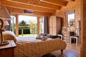 克雷文阿姆斯Finest Retreats - Garden Lodge的小木屋内一间卧室,配有一张床