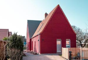 博恩Ferienwohnung Rote Kate的红色的建筑,有 ⁇ 帽屋顶