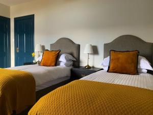 阿勒浦Ardvreck House的两张带橙色枕头的床