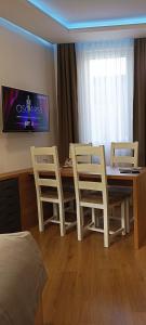 萨拉热窝Apartments "Tuffo"的配有桌椅和电视的客房