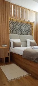萨拉热窝Apartments "Tuffo"的一间卧室配有一张大床和木制床头板