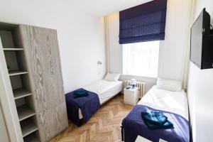 维尔纽斯HOT SPOT Vilnius Apartments!的小房间设有两张床和窗户