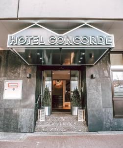 巴德索登陶努斯Concorde Business Boutique Hotel的大楼前方带有标志的酒店门道