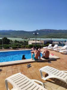 莫拉塔利亚Casa Levante - Casa Rural Los Cuatro Vientos的一群人坐在游泳池旁
