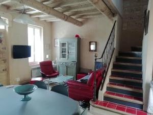 圣马迪拉莫Maison au bord de mer的一间带红色椅子和楼梯的客厅