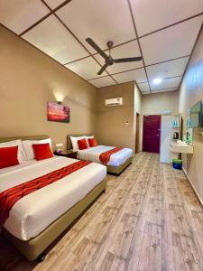 珍南海滩Sri Embun Resort Langkawi的酒店客房配有两张床和吊扇。