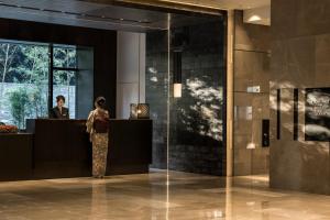 京都Four Seasons Hotel Kyoto的站在大厅柜台的女人