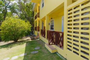 Cap EstateSephina Villa St Lucia Island Dream Holidays的带阳台和庭院的黄色房屋