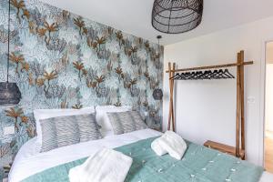 卡朗泰克Sieck - Joli Appartement Vue mer的一间卧室配有一张带花卉壁纸的床