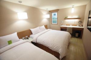 台南康桥商旅 - 台南赤崁楼馆的酒店客房设有两张床和盥洗盆