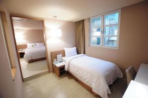 台南康桥商旅 - 台南赤崁楼馆的酒店客房,设有两张床和镜子