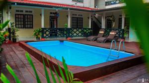 帕拉马里博泽兰迪亚套房酒店的一座房子旁的庭院中的游泳池