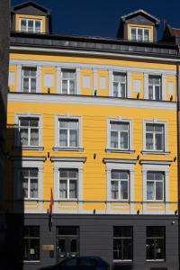 里加Old Riga Plaza Hotel的黄色建筑的侧面设有窗户