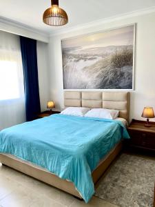 赫尔格达Soma Bay Apartment的卧室配有一张蓝色的床,墙上挂着一幅画