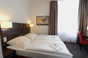 波恩凯瑟尔霍夫贝斯特韦斯特酒店的一张位于酒店客房的床铺,上面有两条毛巾