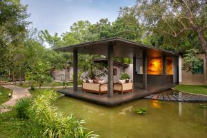 锡吉里亚Atha Resort的前面有池塘的房子