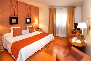 佩德拉萨豪斯佩德里亚圣多明各酒店的酒店客房设有一张大床和一张桌子。