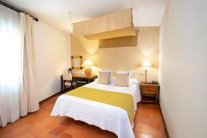 佩德拉萨豪斯佩德里亚圣多明各酒店的一间卧室配有一张黄色和白色毯子的床