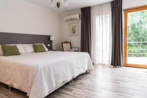 内乌肯莫拉达小酒店的卧室设有白色的床和大窗户