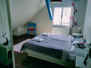 维斯瓦Apartamenty TRZY PTAKI的一间卧室配有两张床和一张蓝色椅子