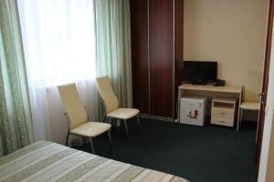 克拉斯诺亚尔斯克贝利多姆酒店的酒店客房配有床、椅子和电视。