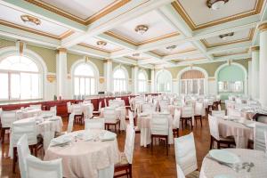 波苏斯-迪卡尔达斯皇宫酒店的宴会厅配有白色的桌椅