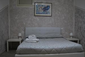 滨海波利尼亚诺Casa vacanze Sabin的一间卧室配有一张带两张桌子和一张照片的床