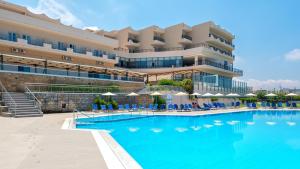 库基尼坎尼奥Themis Beach Hotel的酒店设有一个大型游泳池,配有椅子和遮阳伞