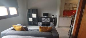 塞维利亚Apartamento Fibes y Congresos的客厅配有带橙色枕头的灰色沙发