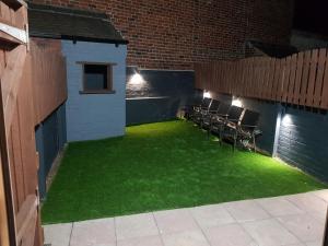 谢菲尔德Highfields Living的一座带绿草和椅子的庭院