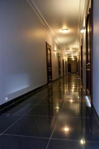 海乌姆利沃夫酒店的建筑的走廊,设有瓷砖地板和灯