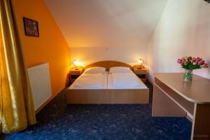 HotemažeGostilna Logar的一间卧室配有一张带两张桌子和两盏灯的床。