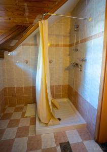 HotemažeGostilna Logar的浴室内设有带黄色淋浴帘的淋浴