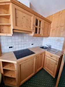 科尔福索Residence Riposo的一个带木制橱柜和水槽的厨房
