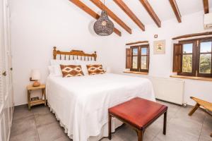 贝尼萨Casa Del Maco的一间卧室配有一张床、一把椅子和窗户。