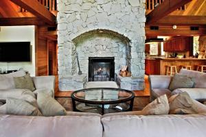 费希坎普Little Ahwahnee Inn Entrance to Yosemite的客厅设有石制壁炉和沙发。