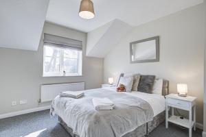 斯劳Windsor Burnham Ascot Haven Sleeps 4的一间卧室设有一张大床和一个窗户。