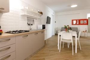 泰拉西尼TERRAVERA的厨房配有白色橱柜和桌椅