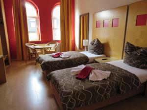 盖尔森基兴Ruhrzimmer的酒店客房带两张床和一张桌子以及椅子。