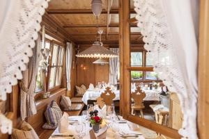 圣安东阿尔贝格Hotel die Arlbergerin ADULTS FRIENDLY 4 STAR的一间设有白色桌椅的用餐室