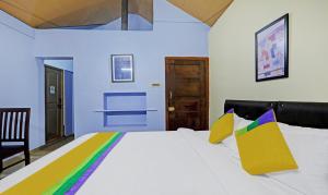 马迪凯里Itsy By Treebo - Allaranda Homestay With Valley View的卧室配有一张带彩色枕头的大型白色床。
