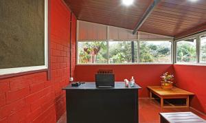 马迪凯里Itsy By Treebo - Allaranda Homestay With Valley View的红色的客房设有一张桌子,上面装有笔记本电脑