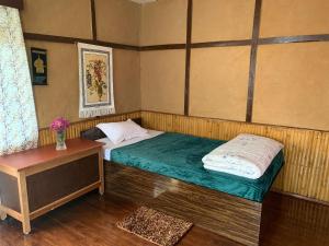 PakhyongKazi Retreat的一间小卧室,配有一张床和一张桌子