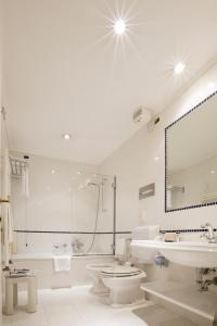 威尼斯普林西皮酒店的白色的浴室设有浴缸、卫生间和水槽。