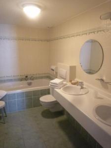 伦德科斯林多斯城堡酒店的带浴缸、卫生间和盥洗盆的浴室