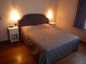 伦德科斯林多斯城堡酒店的一间卧室配有一张带2个床头柜和2盏灯的床。