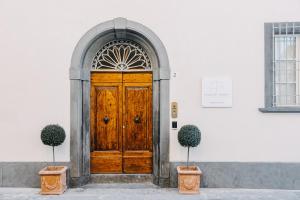 比萨Palazzo Feroci - Residenza d'epoca的白色建筑的木门,两棵植物