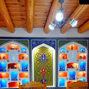 布哈拉Koh-i-noor的一间拥有蓝色和绿色瓷砖及天花板的客房