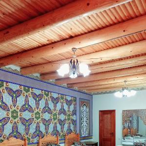 布哈拉Koh-i-noor的一间设有木天花板和瓷砖墙的用餐室