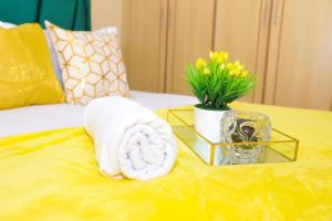 RuiruThe Ivy Suite- one bedroom 3 mins away from Ruiru Rainbow Resort的桌子上一条毛巾和花瓶